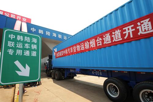 7月1日，在烟台国际集装箱码头，满载着运往韩国货物的集装箱车在通过中韩陆海联运车辆.jpg