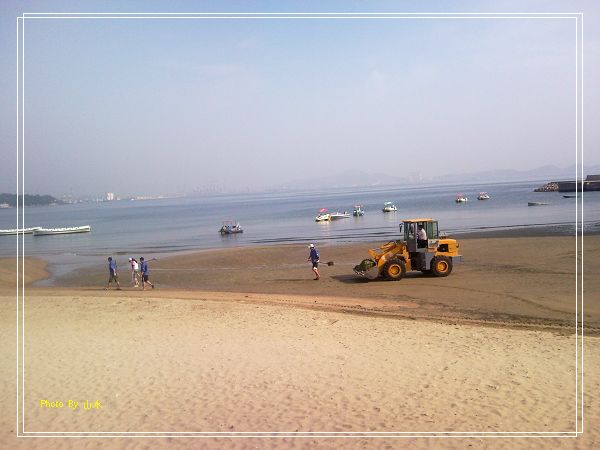 海边沙滩上清理垃圾的工人