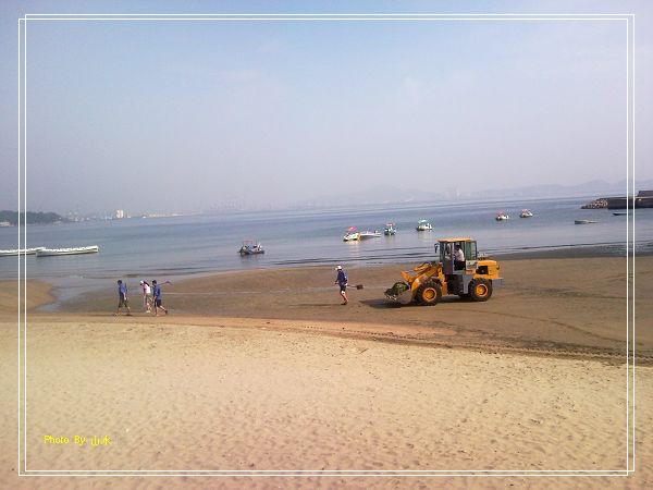 海边沙滩上清理垃圾的工人