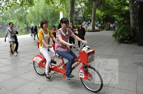 涌金池旁，两位游客正在骑公共双人自行车。_副本.jpg